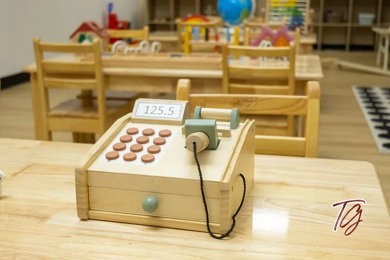 A wooden toy cash register on a table