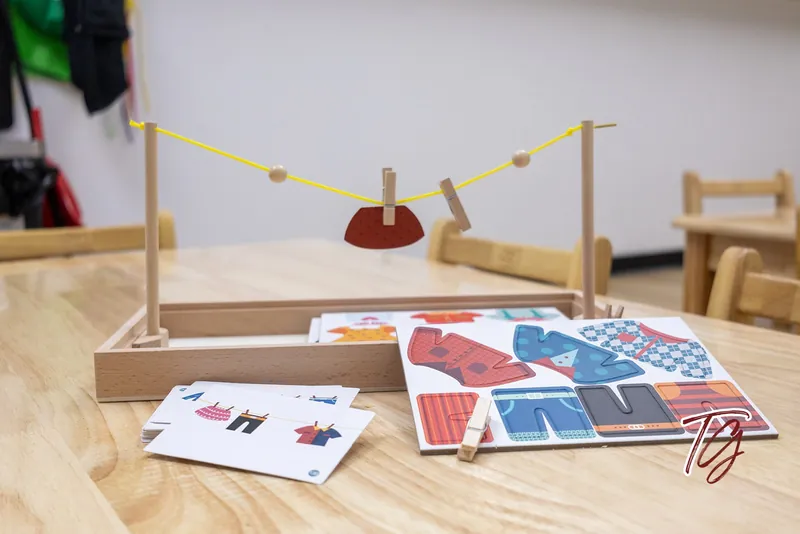 A clothesline pegging activity set out on a table