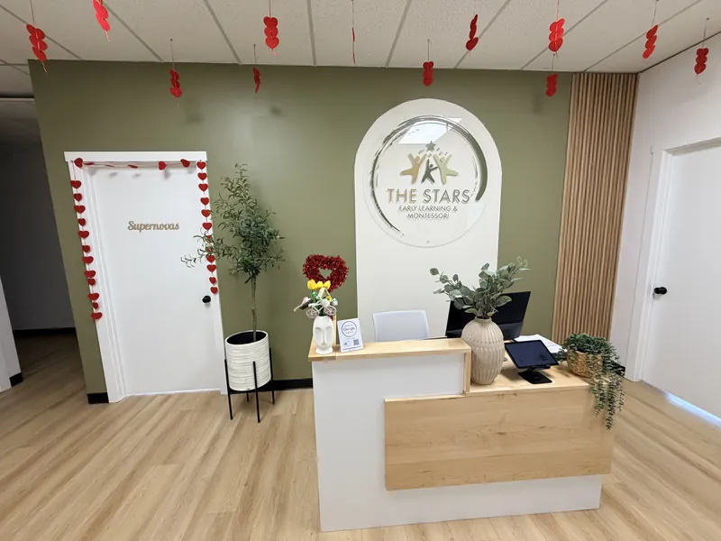 Our front desk, with The Stars logo on an olive wall, plants and the door to the Supernovas room