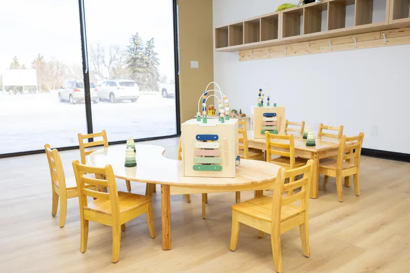 A round table set with toys beside a big window