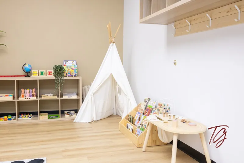 Montessori shelves, a book display and a low table beside a tipi