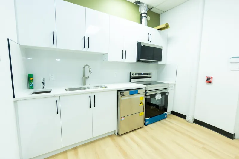 Our kitchen: a sink, dishwasher, stove and microwave beside a green accent wall